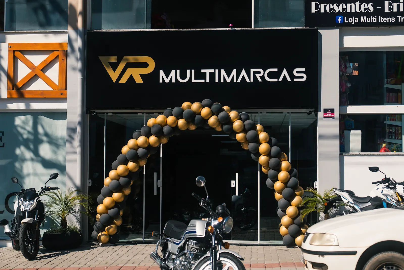 Fachada da VR Multimarcas Treze Tílias com arco de balões e motos na calçada