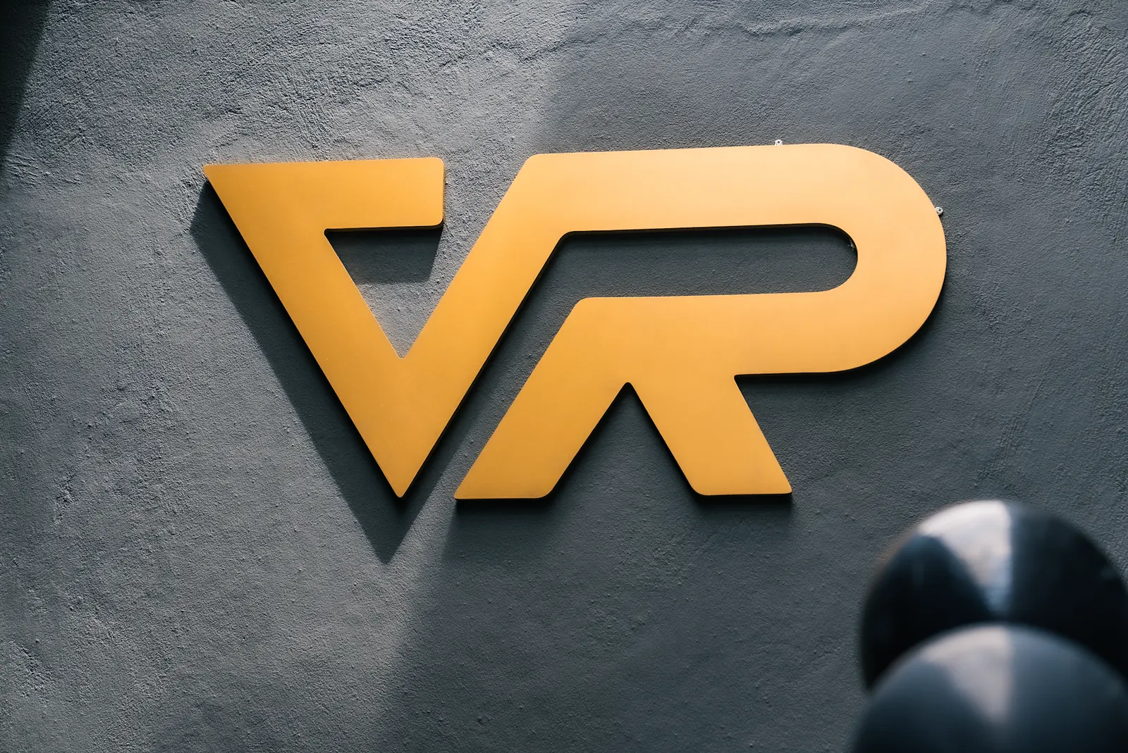 Logo dourado da VR em uma parede de loja